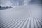 Pattern of a freshly groomed ski slope in front of a big kicker in a snowpark in St.Anton