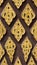 Pattern of gold flower carved on stucco design of native wall