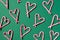 Pattern with hearts made of Christmas candy canes on green background. Top view. Flat lay. Love, Valentines day concept. New year