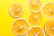 Pattern from homemade oven dried dehydrated citrus fruits oranges on bright yellow background. Ingredient for hot beverages