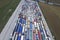 A pattern of many trucks taken down from a height. Trucks lined up to unload grain at the port