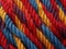 Pattern of multicolored twisted and intertwined ropes and threads.