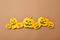 Pattern of paper handcraft pumpkins with scary faces on a brown background with copy space. Composition for Halloween