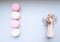 Pattern of pink and cream macaroons and an angel handmade figurine with a candlestick.