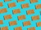 Pattern from scandinavian rye whole grain crispbreads with sesame seeds on solid blue background. Harsh shadows hard light. Trendy