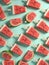 Pattern of watermelon icecreams on sticks on mint background, flat lay, summer refreshing snack, AI generated