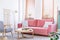 Patterned armchair next to pink sofa in bright flat interior wit