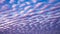 Patterned fluffy purple or ultra violet clouds in blue sky
