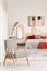 Patterned wooden armchair in bright orange bedroom interior with