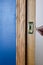 Patterned wooden and metal door next to blue wall