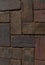 Paved aged bricks pavement of dark red-brown stones, close-up top view above of cobblestones for background or texture