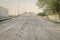 Paved bridge going uphill filled with potholes and surface erosion