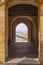 Paved corridor with an arch on the buildings overlooking the port of Cefalu