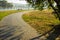 Paved curved empty cycle road under trees in park outdoor country side natural environment place for rest and walking in morning