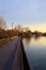 Paved footbridge in a park over a lake at sunset