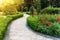 paved path in beautiful landscaped garden. flowerbed with red roses
