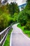 Paved path among the green Italian woods in the European summer, holidays in the mountains