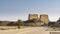 A paved sidewalk leads to the ancient Egyptian temple of Horus in Edfu.