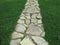 Paved stone brick walkway through green grass