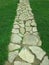 Paved stone brick walkway through green grass