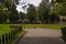 Paved walking paths and lawns in lonely city park on summer day