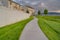 Paved walkway in front of homes with view of a pond and vast grassy terrain