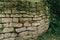 Paved wall with a rough, clear texture and deep lines between large stones. Laying an old fence. Destroyed stone fence