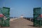 Pavement that leads to a lighthouse captured in coastal North pier on a bright day under a clear sky