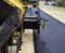 Pavement machine laying fresh asphalt or bitumen