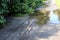 On the pavement after the rain visible traces of wheels coming out of the puddle