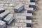 Pavement repairs and paving slabs laying on the prepared surface, with tile cubes in the background. Laying paving slabs in the