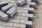 Pavement repairs and paving slabs laying on the prepared surface, with tile cubes in the background. Laying paving slabs in the