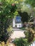 Pavers form a winding pathway through a garden bordered by a white picket fence, Old Monterey, California.