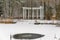 Pavilion with columns and winter lake in the park