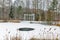 Pavilion with columns and winter lake in the park