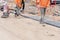 Paving stone workers filling joints of block paved footpath with dry sand during the construction of a new road