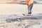 Paving stone workers filling joints of the block paved footpath with dry sand during the construction of new road