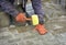 Paving the tiles on the sidewalk, the worker lay the tile, aligning it on the thread