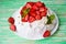 Pavlov`s cake with strawberries and cream on a rustic background