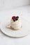 Pavlova berry cake with blueberries, raspberries and vanilla whipped cream on a marble background