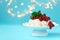 Pavlova birthday fruit cake with strawberry, raspberry, red currant and mint leaves on pastel blue background against blurred