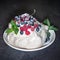 Pavlova meringue with whipped cream, fresh blueberries, raspberries, yellow raspberries, cherries and classic chocolate mint leave