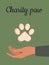 Paw of a cat or dog on a green vertical banner. Pet care. Charity paw. Symbol of helping animals in shelters and veterinary