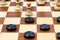 Pawn and checkers piece in center of board closeup