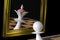 The pawn looks in the mirror, the Queen in the reflection. On a black background. 3D-rendering, illustration