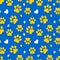 Paws of a cat, dog, puppy. Seamless cute pattern of animal footprints for textile. Blue and yellow colors.
