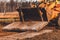 Paws of the excavator. The bucket excavator pulls up concrete slabs to set the road