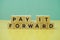 Pay It Forward alphabet letter on green and yellow background