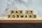 Pay It Forward alphabet letter on marble and wooden shelves background