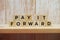 Pay It Forward alphabet letter on shelves wooden background